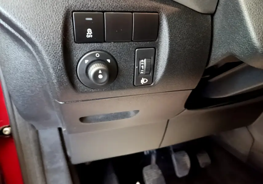 Détail du tableau de bord côté gauche du Citroën Berlingo rouge 2016 avec commandes d’éclairage et pédales visibles.