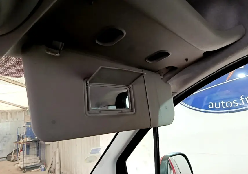 Miroir de courtoisie ouvert côté conducteur dans l'habitacle d'un Citroën Berlingo rouge 2016, vue intérieure rapprochée.
