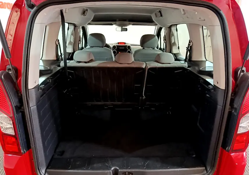 Vue arrière du coffre ouvert du Citroën Berlingo rouge 2016, montrant l'espace intérieur et la banquette arrière.