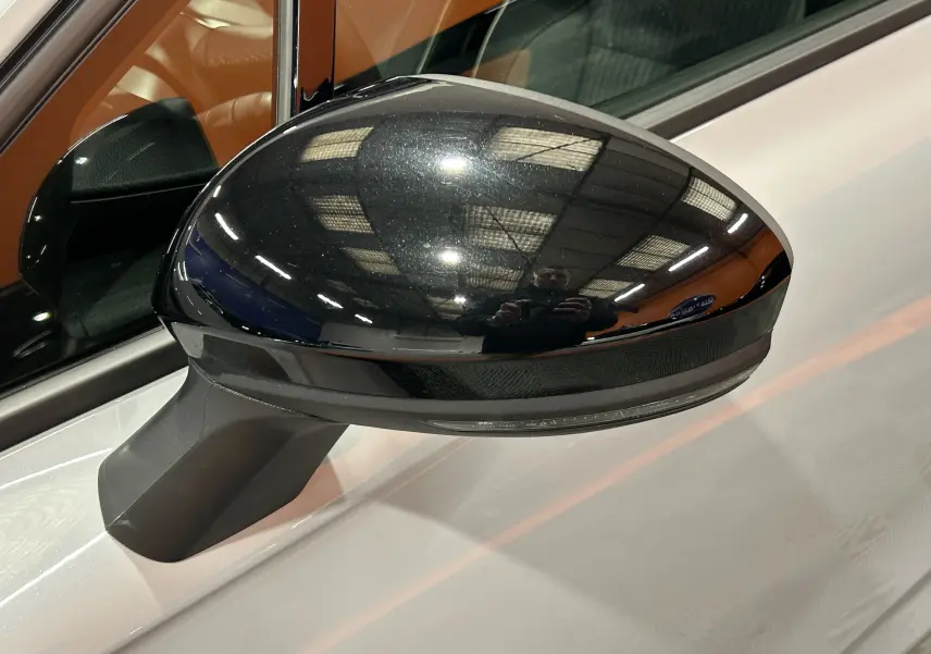 Rétroviseur côté gauche noir brillant sur Renault Clio V gris Rafale Métal, vue rapprochée sur la portière avant.