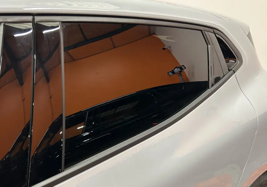 Vue latérale droite sur la porte arrière d'une Renault Clio V E-Tech gris Rafale métallisé avec vitres teintées.