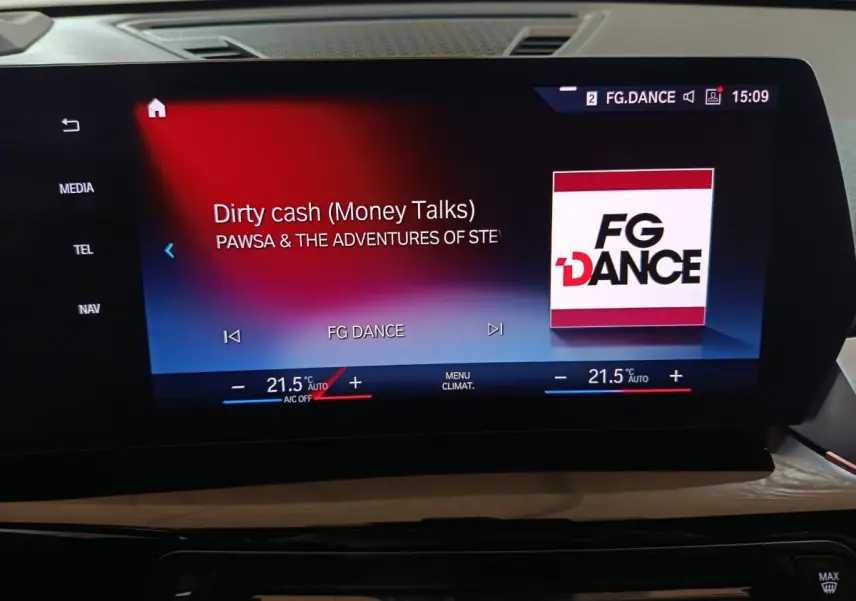 Écran tactile central du tableau de bord du BMW X1 noir, affichant la radio FG Dance et la climatisation à 21,5°C.