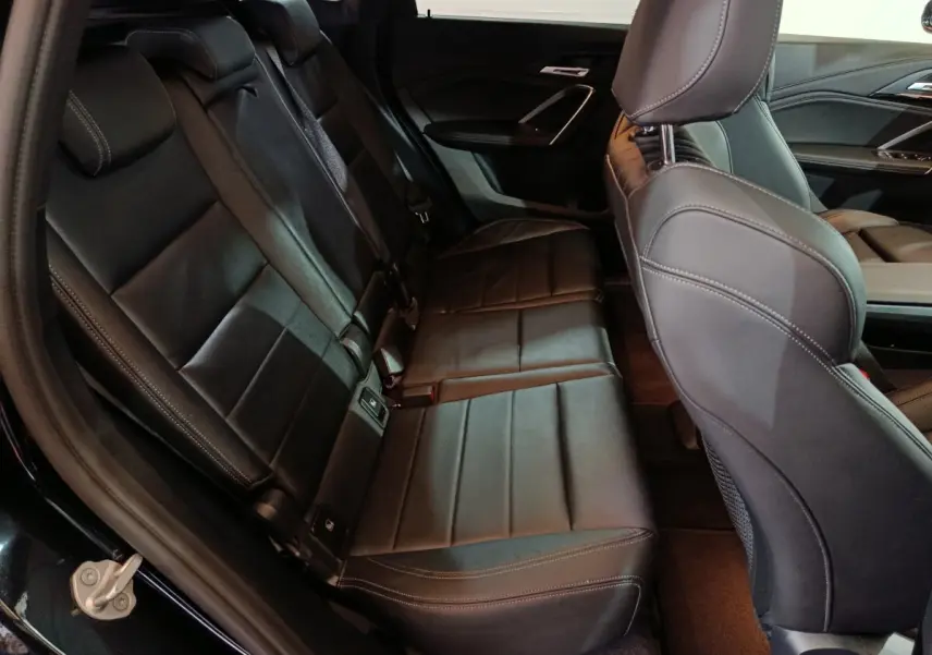 Vue intérieure côté arrière gauche montrant la banquette noire en cuir du BMW X1 xDrive23i M Sport 2023.