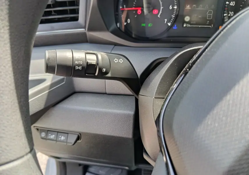 Gros plan sur la manette de clignotants et commandes d’éclairage à gauche du volant du Renault Master 2025, intérieur noir.