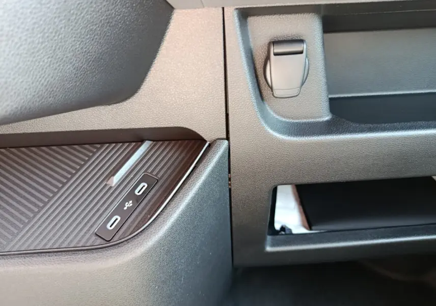 Gros plan sur la console centrale du Renault Master blanc 2025, montrant les ports USB-C doubles et un rangement ouvert.