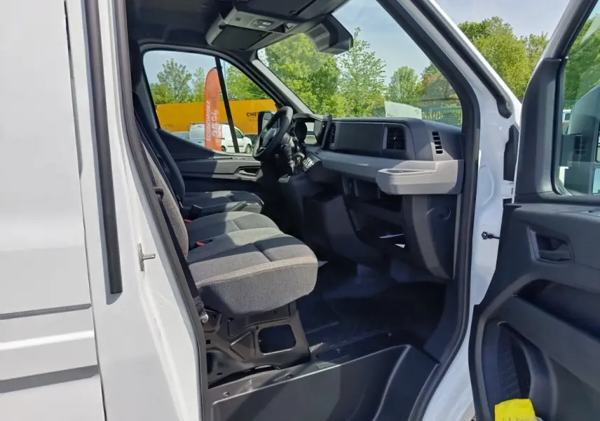 Vue intérieure côté conducteur du Renault Master blanc 2025, montrant les sièges et le tableau de bord moderne.