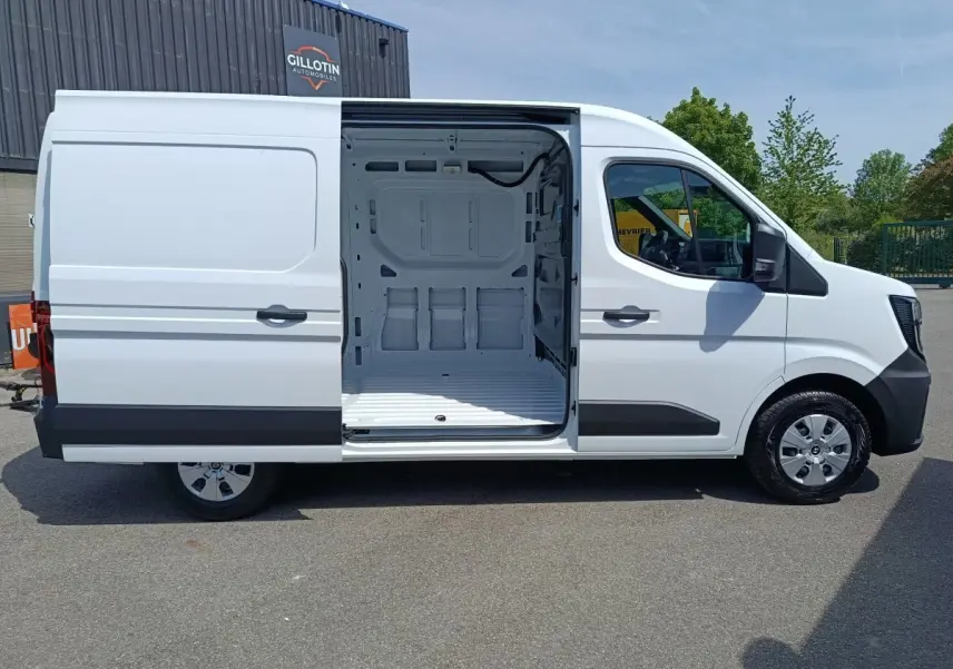 Vue latérale droite d’un Renault Master blanc 2025 avec porte coulissante ouverte montrant l’espace de chargement vide.
