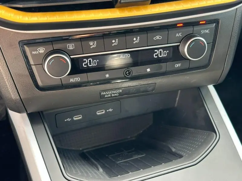 Vue rapprochée de la console centrale du SEAT Arona 2025 avec commandes climatisation automatique et ports USB.