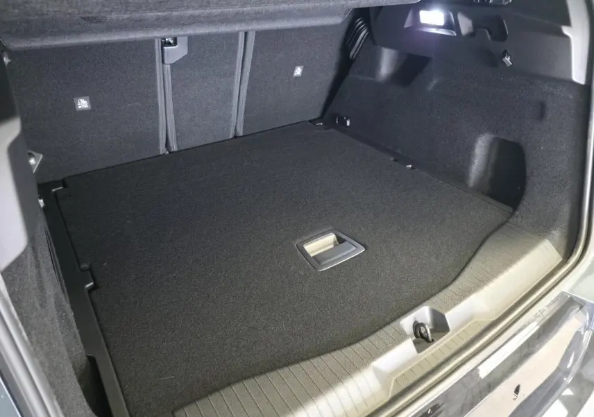 Vue intérieure du coffre du Citroën C5 Aircross vert, montrant le plancher plat et l'éclairage intégré.