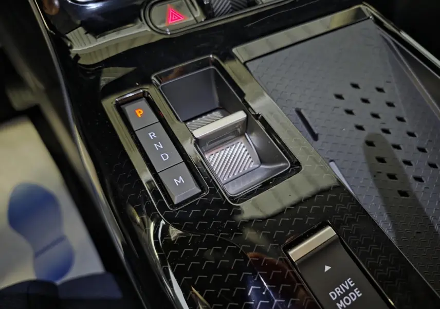 Gros plan sur la console centrale noire brillante avec sélecteur de boîte auto et bouton Drive Mode du Citroën C5 Aircross vert.
