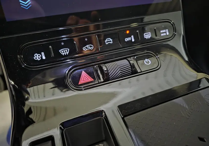Gros plan sur la console centrale noire brillante du Citroën C5 Aircross 1.2i Hybride avec commandes tactiles et bouton de warning.