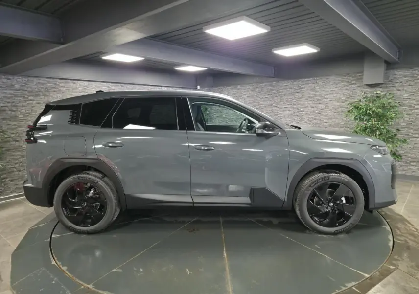 Vue de profil côté gauche d'un Citroën C5 Aircross gris métallisé avec jantes noires en intérieur.