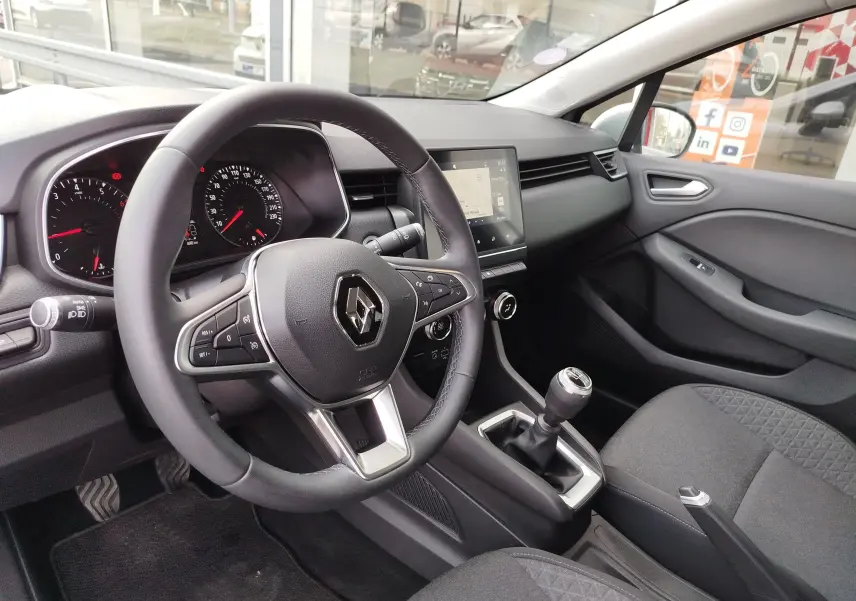 Vue intérieure côté conducteur de la Renault Clio V Business 2020, volant cuir, tableau de bord moderne et levier de vitesses manuel.