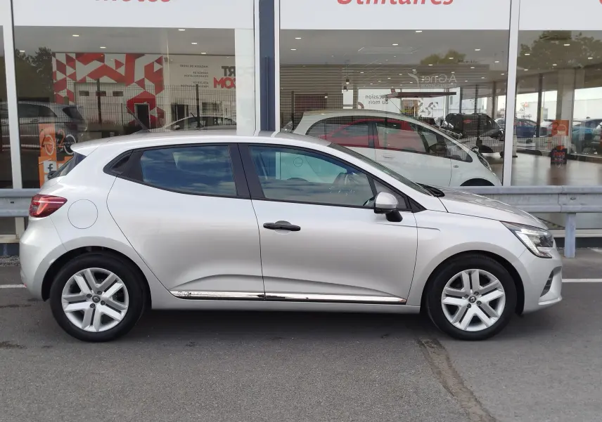 Profil côté gauche d'une Renault Clio V Business gris platine, avec jantes alliage et lignes épurées visibles.