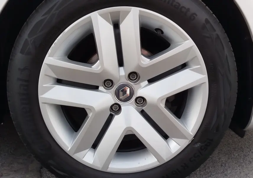 Gros plan sur la jante en alliage argentée d'une Renault Clio V Business gris platine, avec logo Renault au centre.
