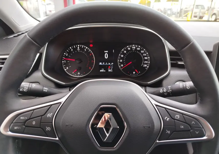 Vue rapprochée du volant noir et du tableau de bord numérique de la Renault Clio V Business 2020, avec logo central visible.