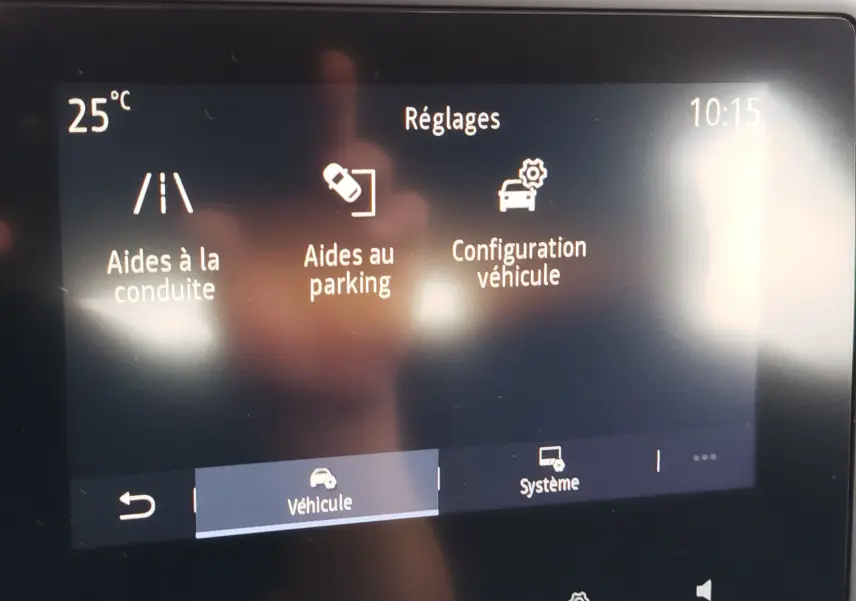 Écran tactile intérieur de la Renault Clio V Business montrant les réglages d’aides à la conduite, parking et configuration véhicule.