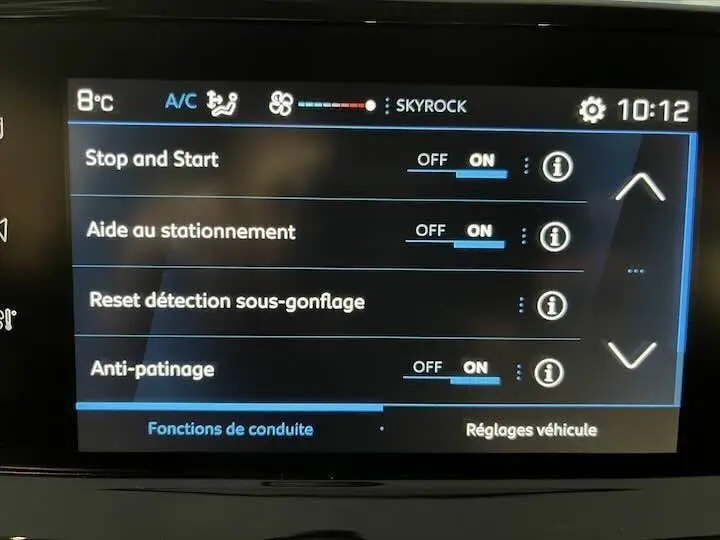 Écran tactile intérieur du Peugeot 208 rouge Elixir Metal montrant les réglages d’aide à la conduite activés.