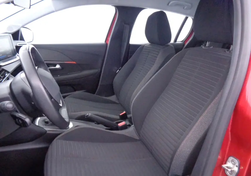 Intérieur avant droit d'une Peugeot 208 rouge Elixir Metal, sièges noirs et tableau de bord moderne visible.