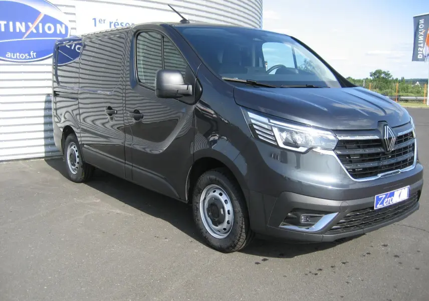 Renault Trafic Fourgon gris comète vu en 3/4 avant droit, avec calandre chromée et jantes acier simples.