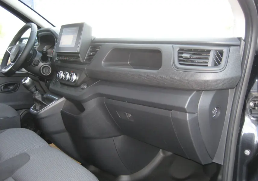 Intérieur côté passager du Renault Trafic Fourgon gris comète 2025, tableau de bord avec écran tactile et commandes manuelles.