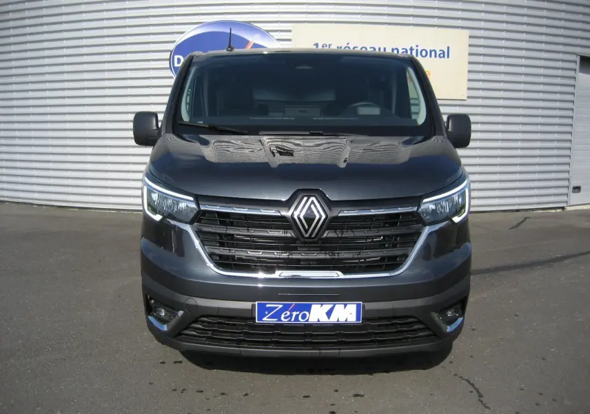 Vue frontale d'un Renault Trafic Fourgon L1H1 Advance gris comète avec calandre noire et phares LED allumés.