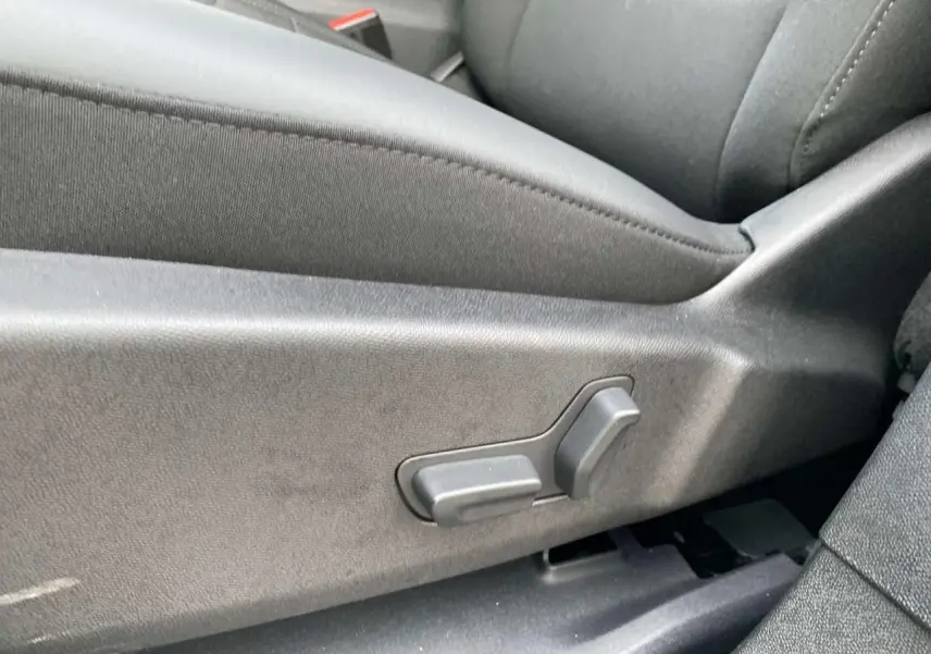 Gros plan sur les commandes électriques du siège avant en tissu gris foncé du Citroën C5 Aircross 2025.