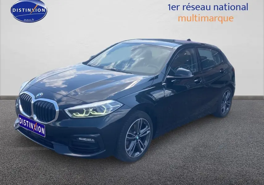 BMW Série 1 noire vue en 3/4 avant droit avec phares LED allumés et jantes alliage 17 pouces double rayons.