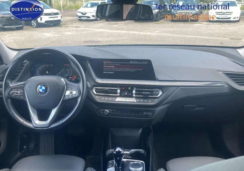 Vue intérieure frontale du tableau de bord noir de la BMW Série 1 (f40) 118i avec volant multifonction et écran central.