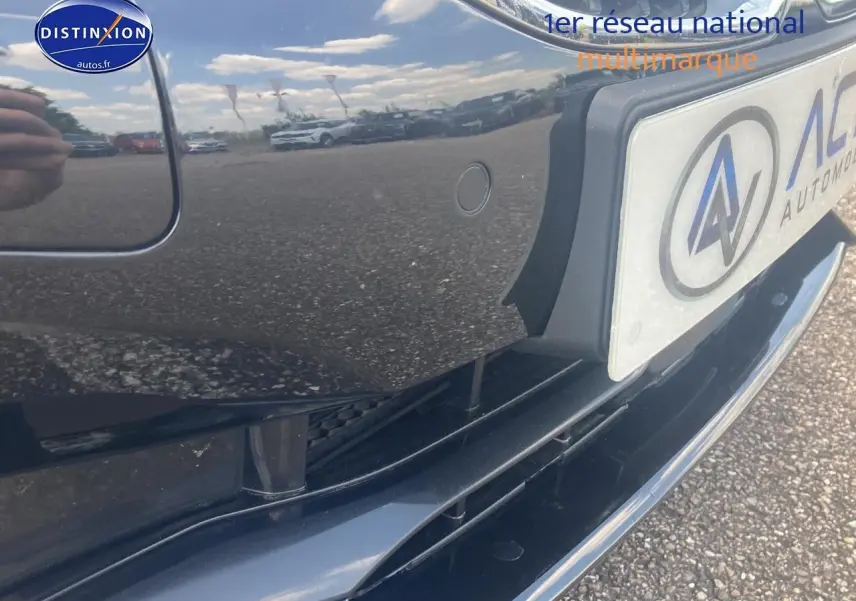 Gros plan sur le pare-chocs avant noir brillant de la BMW Série 1 (f40) 118i avec capteur de stationnement visible.