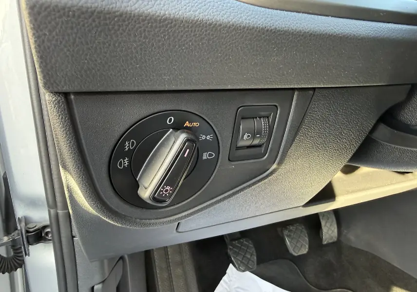 Gros plan sur le bouton de commande des phares côté gauche dans l’habitacle d’une Volkswagen Polo gris métal 2021.