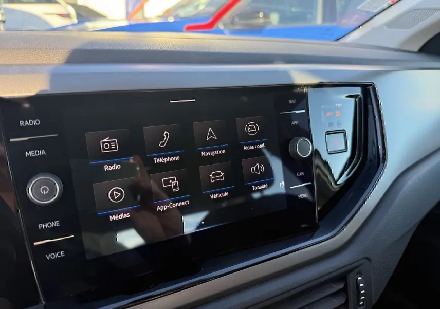 Écran tactile central du tableau de bord d'une Volkswagen Polo 2021, affichant les options multimédia et navigation.
