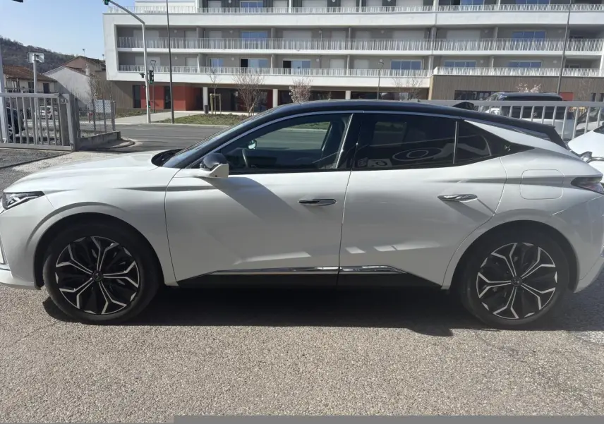 Vue latérale gauche d'une DS4 2023 blanche avec toit noir et jantes alliage noires au design distinctif.