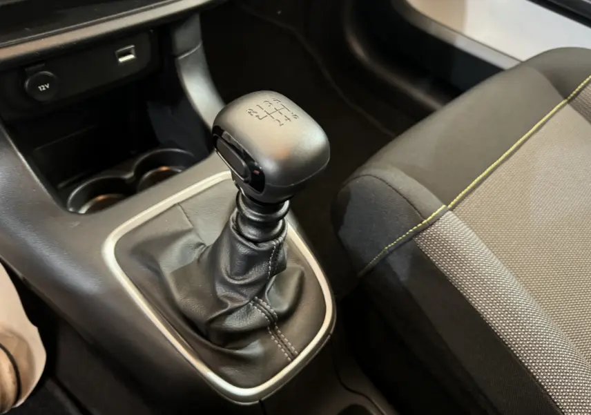 Le levier de vitesses manuel noir de la Citroën C3 2020, avec siège tissu gris et surpiqûres jaunes visibles.