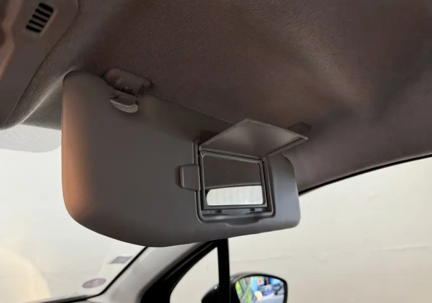 Détail intérieur du pare-soleil côté conducteur avec miroir ouvert sur Citroën C3 gris foncé, vue depuis l'habitacle.