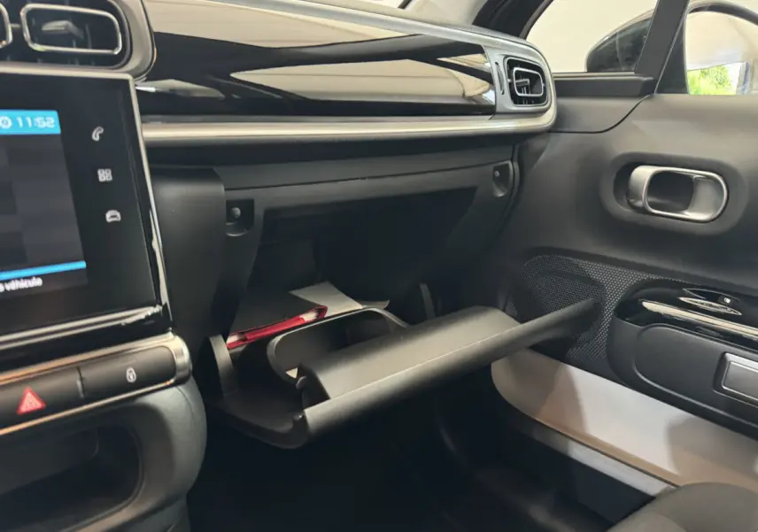 Vue intérieure côté passager de la Citroën C3 gris foncé 2020, boîte à gants ouverte avec tableau de bord noir brillant.