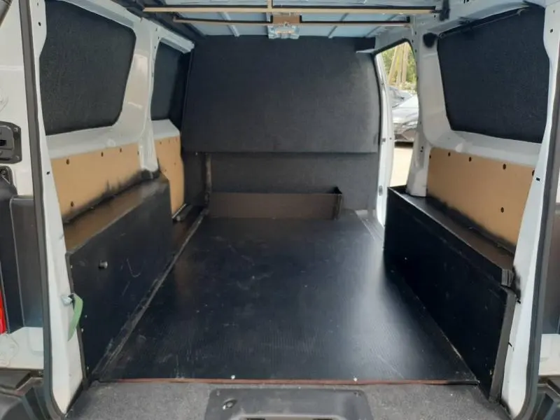 Vue intérieure arrière du Peugeot Expert Fourgon blanc 2025, montrant l'espace de chargement vide avec habillage noir et beige.