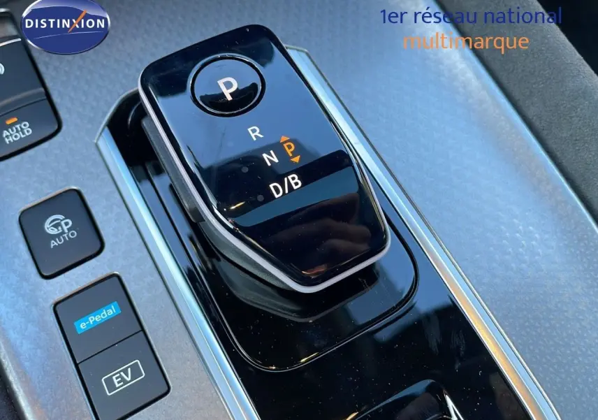 Gros plan sur la commande de boîte automatique noire du Nissan Qashqai blanc nacré au design moderne.