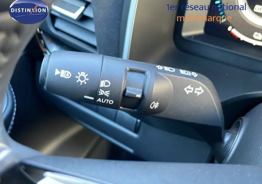 Gros plan sur la manette des feux et clignotants du Nissan Qashqai 1.5 VCT E-POWER, intérieur noir.