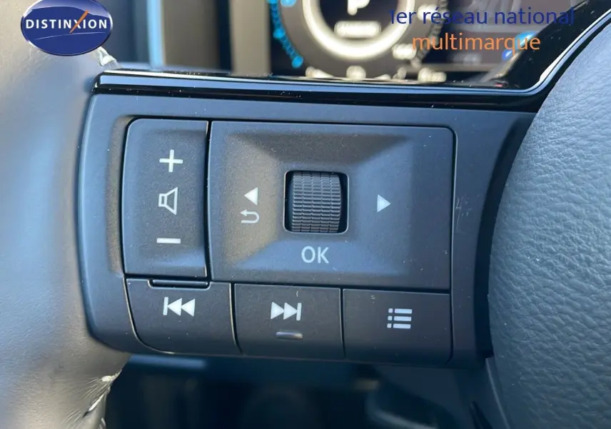 Gros plan sur les commandes au volant noir du Nissan Qashqai blanc nacré avec toit noir, version N-Design.