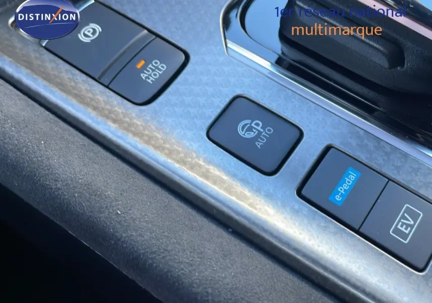 Gros plan sur la console centrale du Nissan Qashqai blanc nacré, mettant en valeur les boutons e-Pedal et EV.