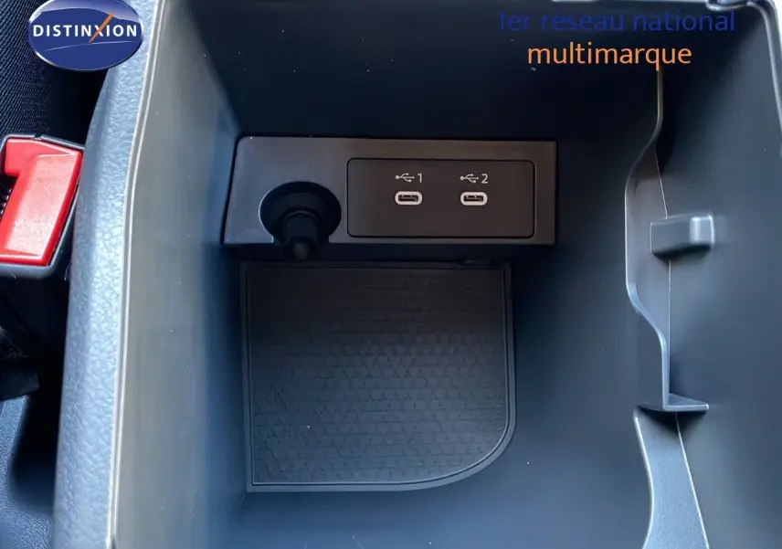 Gros plan sur la console centrale du Nissan Qashqai blanc nacré, montrant deux ports USB et un allume-cigare.