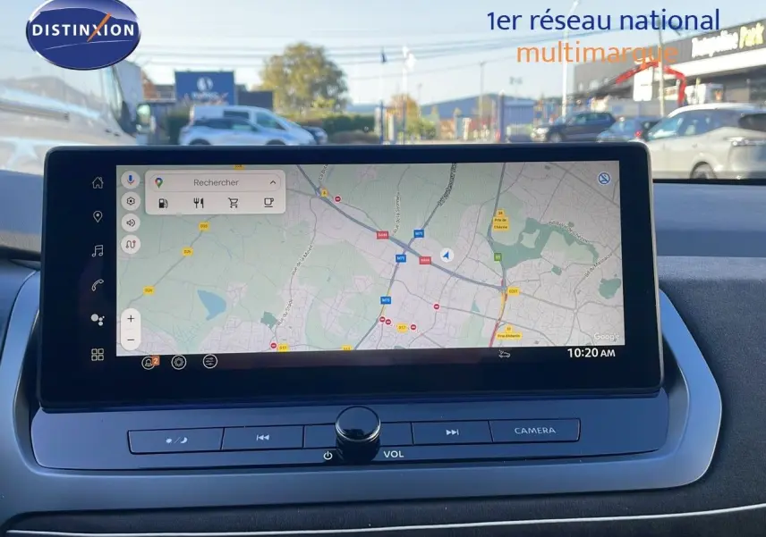 Écran tactile central du Nissan Qashqai blanc nacré, affichant une carte GPS avec commandes multimédia en bas.