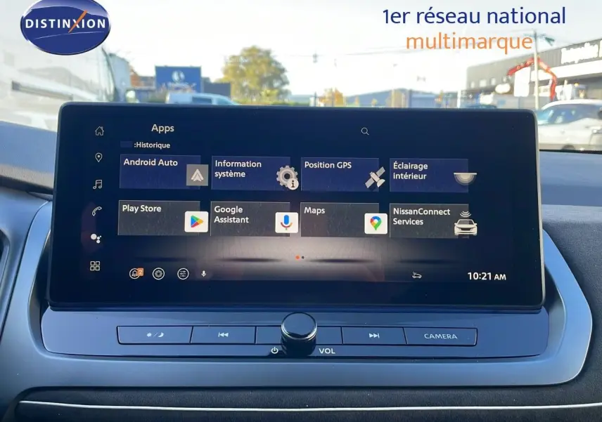 Écran tactile central affichant les applications connectées du Nissan Qashqai blanc nacré au toit noir, vue intérieure frontale.