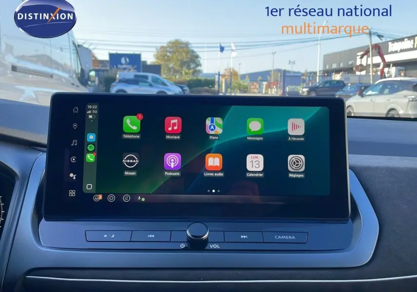 Écran tactile central du tableau de bord du Nissan Qashqai blanc nacré avec toit noir, affichant les applications connectées.