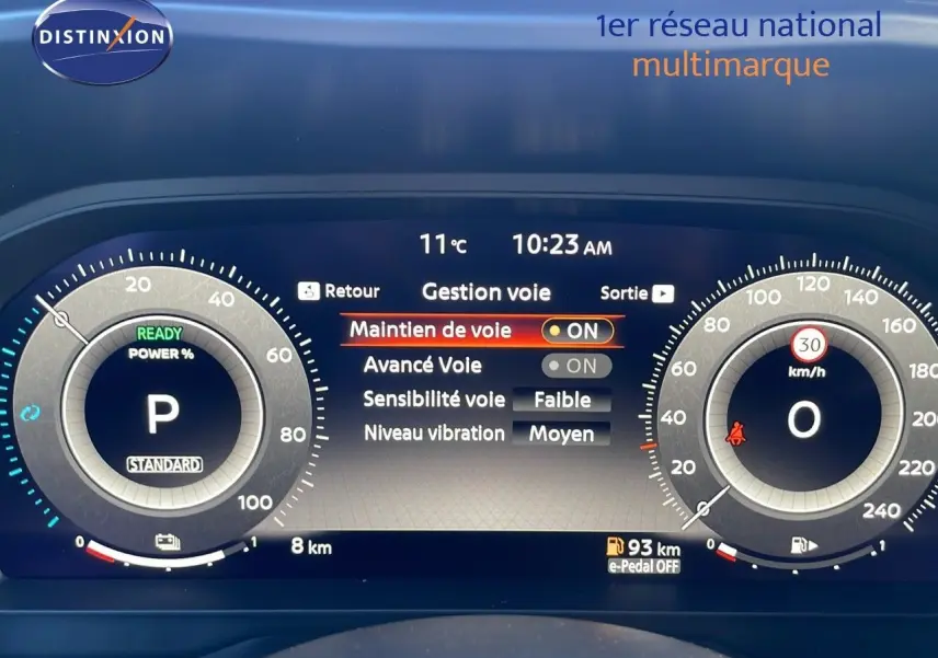 Tableau de bord numérique du Nissan Qashqai blanc nacré, affichant la gestion des aides à la conduite et la vitesse à 0 km/h.