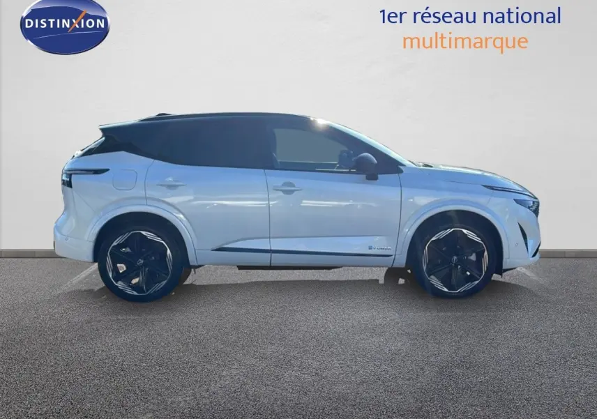 Profil droit du Nissan Qashqai blanc nacré à toit noir, avec jantes noires et lignes modernes visibles.