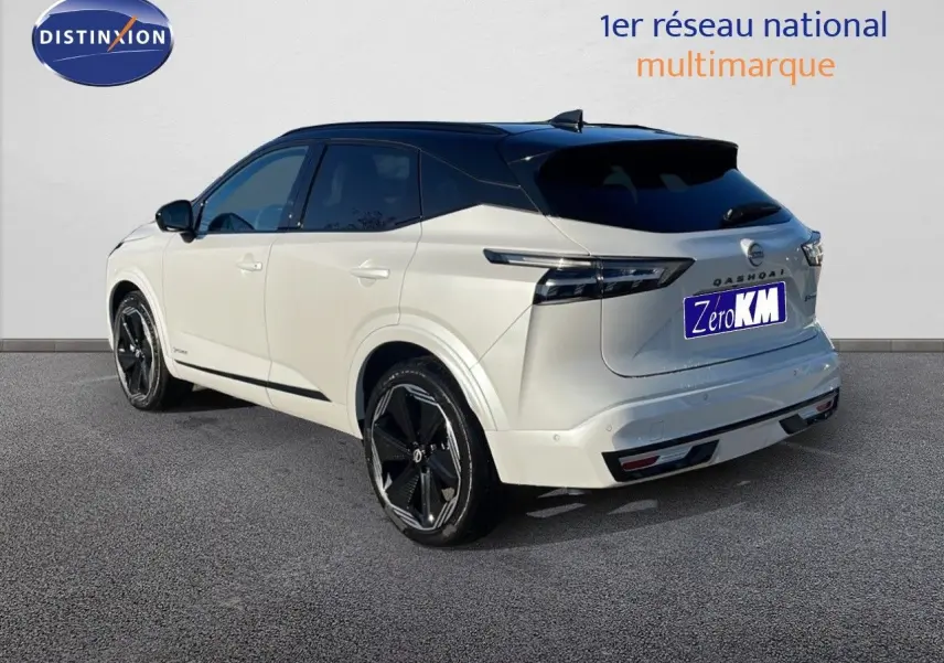 Vue 3/4 arrière droite du Nissan Qashqai blanc nacré avec toit noir, jantes noires et feux arrière LED modernes.