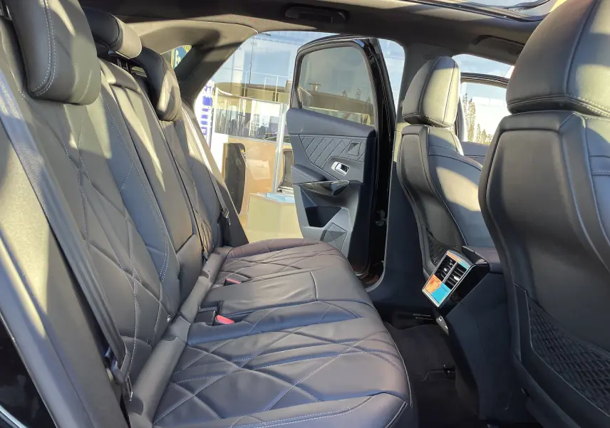 Vue intérieure arrière droite du DS7 2024 noir Perla Nera, mettant en valeur les sièges en cuir noir matelassé et la porte ouverte.