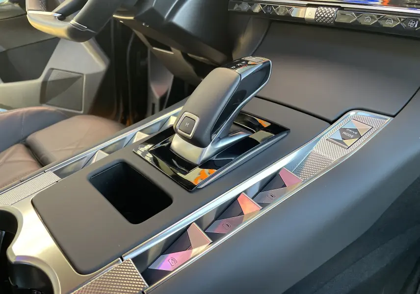Gros plan sur la console centrale du DS7 2024 noir Perla Nera, mettant en valeur le levier de vitesse automatique et les commandes design.